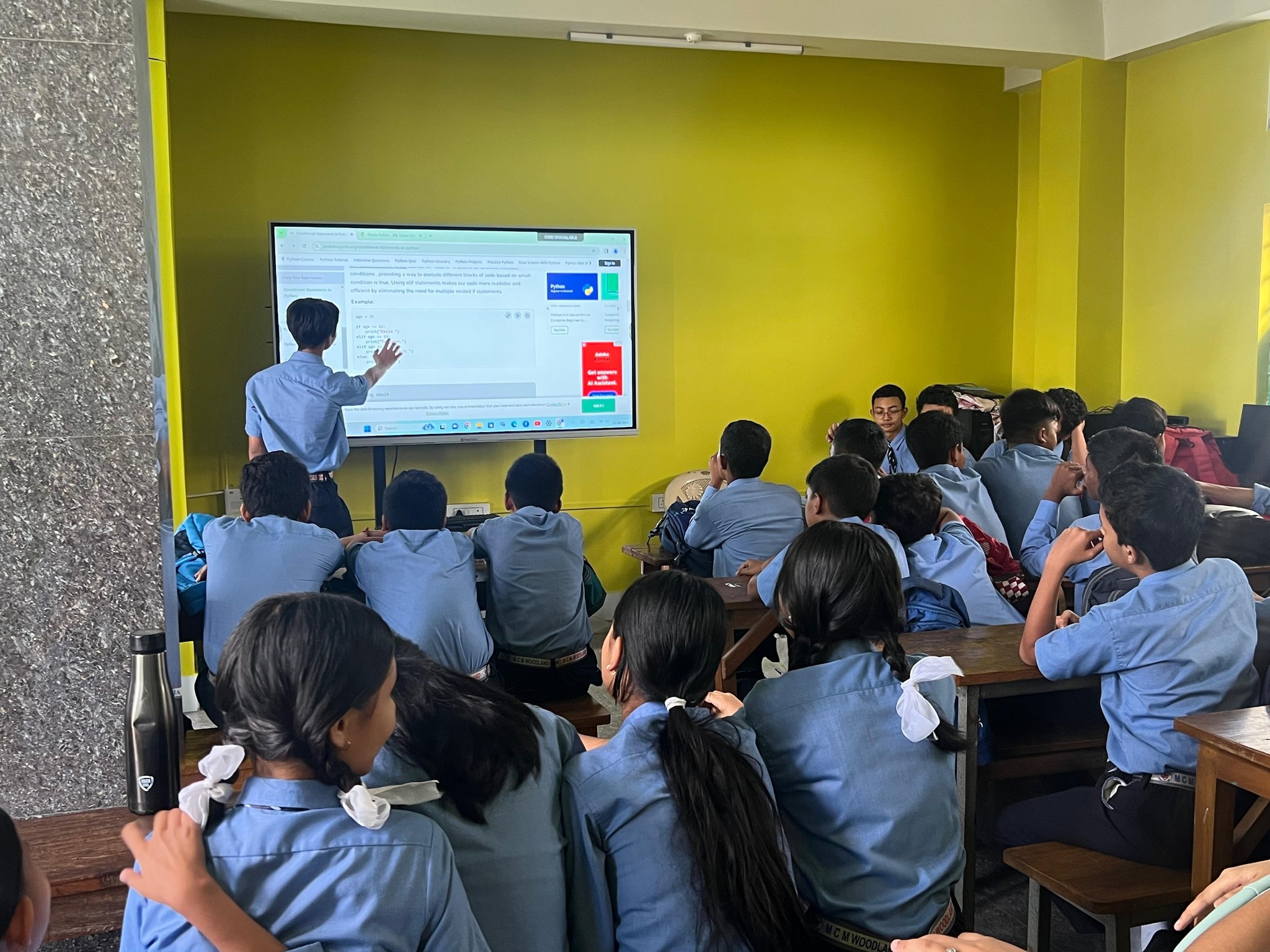 Teacher using interactive digital board in classroom